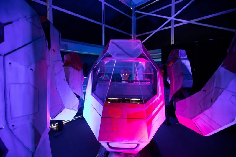 A pod-like prop inside the garage set under purple light