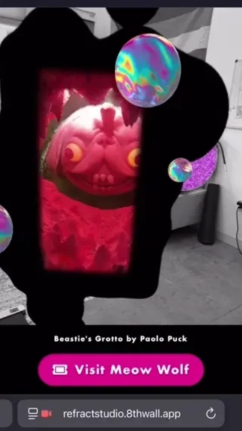 A phone showing an AR portal into a red room with a visit button